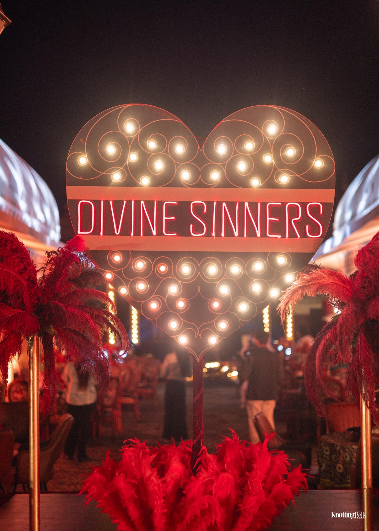 Divine Sinners neon heart marquee sign with red feathers