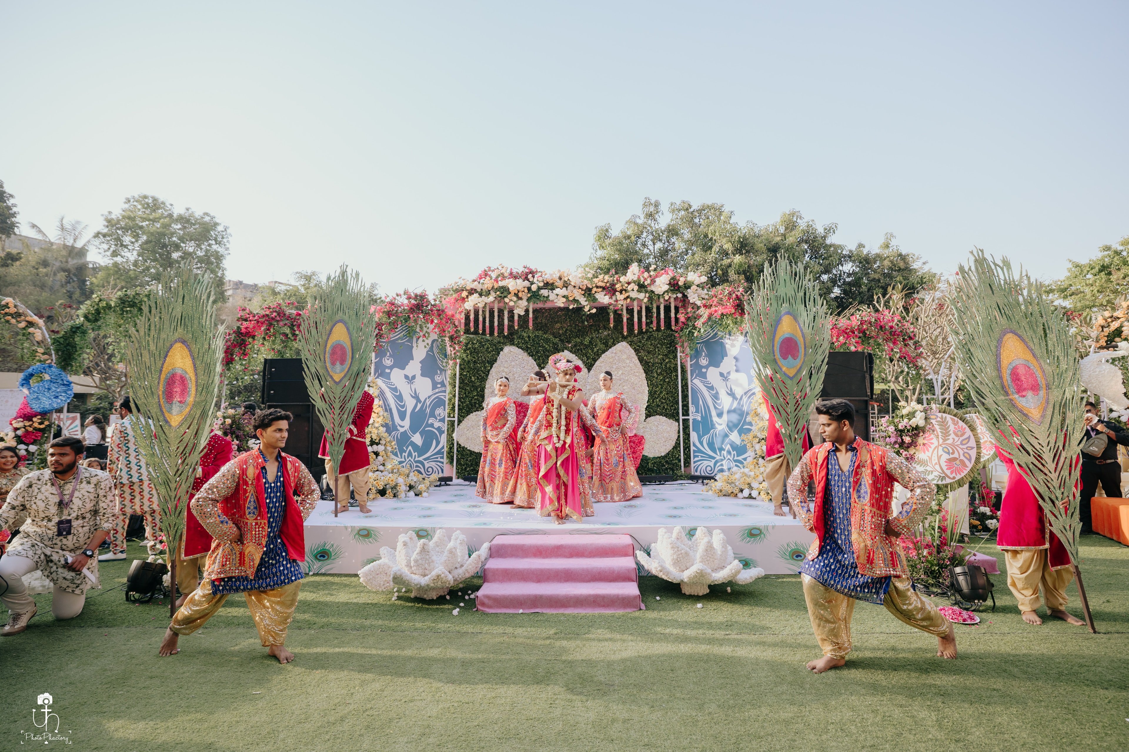 Outdoor wedding performance with peacock décor