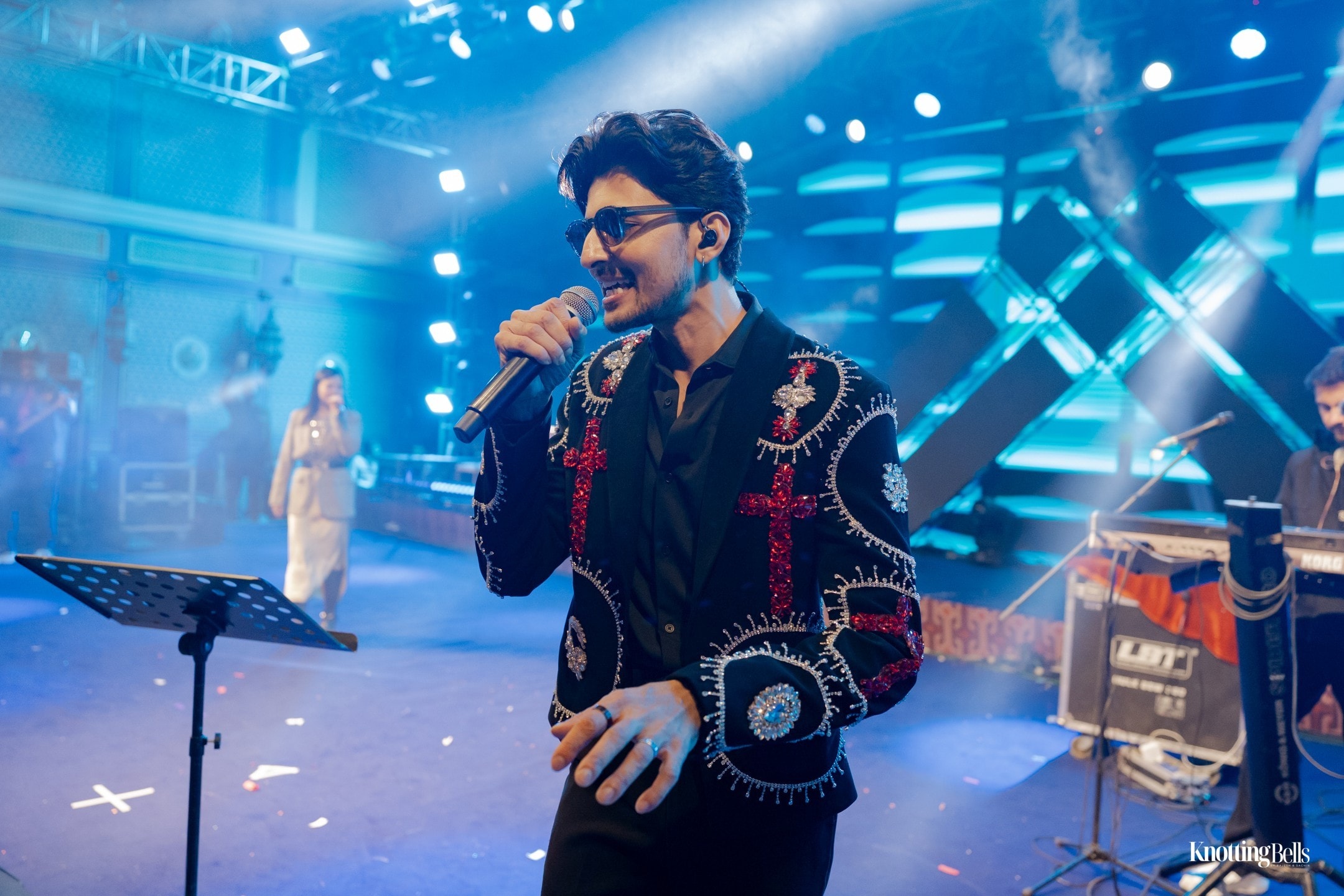 Live performer on stage at sangeet with blue lighting